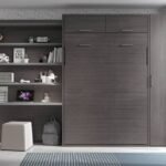 Bedroom with a vertical folding double bed and study area.